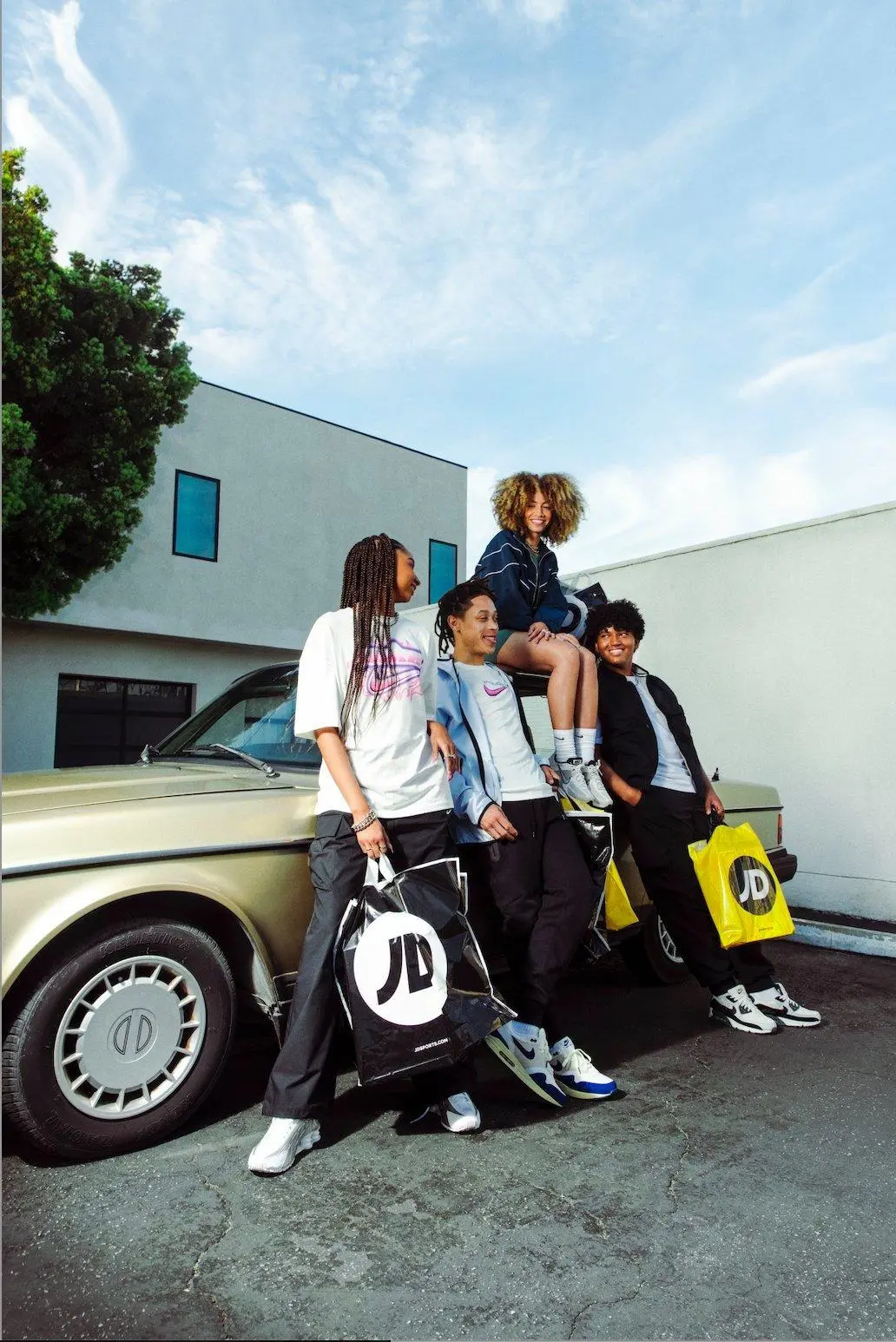 Group of people by car with JD bags